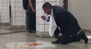 man eats pasta off subway florr